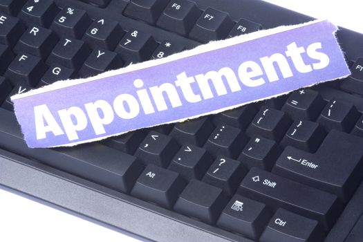 Image of a newspaper cutting with the words Appointment placed on a computer keyboard.