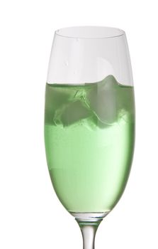 Bright green drink in a tall champagne glass with ice cubes