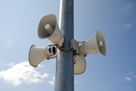 four megaphone hanging on a pole