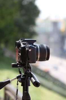 Woman photographer holding a photo camera outdoors.