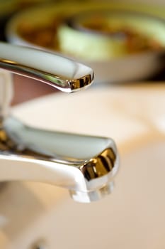 tap of a clean washbasin with ornament on the background