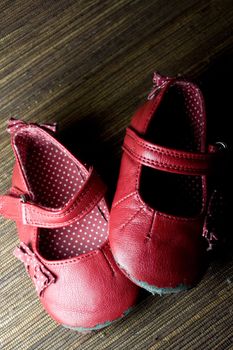 worn and used red baby girl shoes