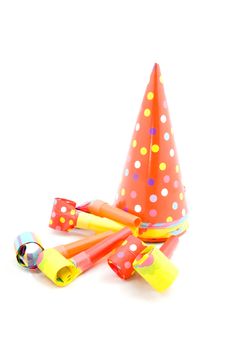 colorful partyhats and party whistles isolated on white