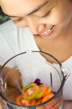 pretty asian young woman preparing to make vegetables juice 