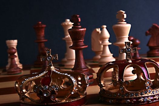 Chessmen on a game board with two crowns.