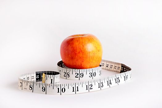 Tape measure and an apple characterise diet possibility.