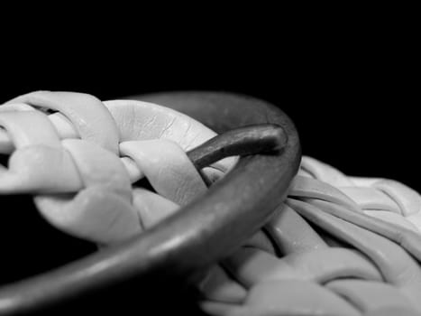 Black and white belt in the black background. In the centre strap. 