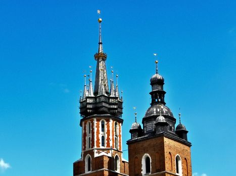 Big and small curch towers. Blue sky in the background. Photo was taken in Cracow, Poland. 