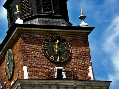 Part of tower with a clock. The clock with gold hands. 