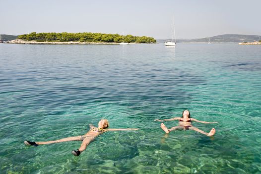 Two women swim in Adriatic sea, Croatia 