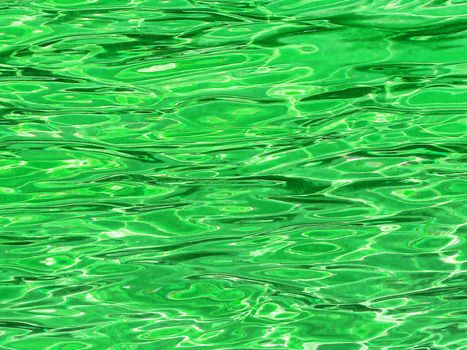 Green water background with ripple and sun reflection