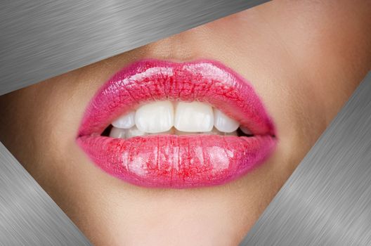 Beautiful female lips closeup behind silver metal background