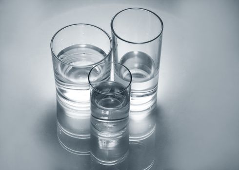 Three different glass glasses with water
