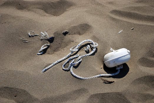 Rope with Knots on the Sand as Shipwreck Concept