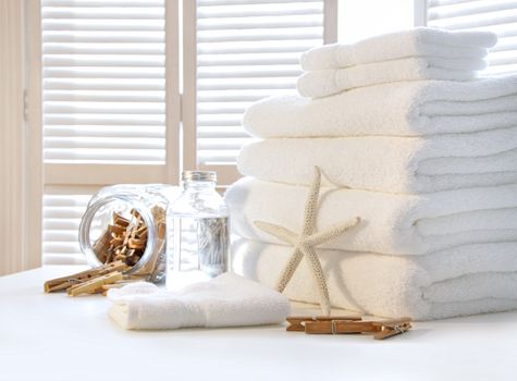 Fluffy white towels on table with shutter doors 