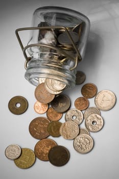 coins from various countries spilled out of a bottle