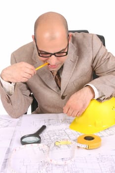 Businessman thinking with architectural plans on white background