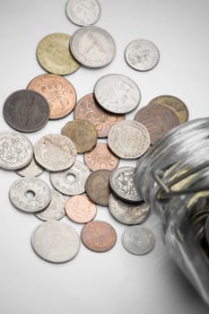 coins from various countries spilled out of a bottle