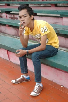 young man get smoking cigarette while sit down on stair