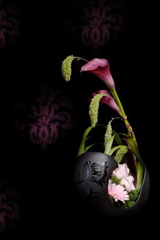 Flower arrangement with amaryllis isolated on black ornamented background