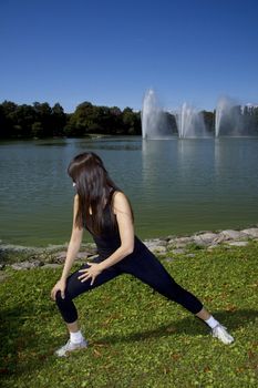 Latina is working out in the park stretching before a run