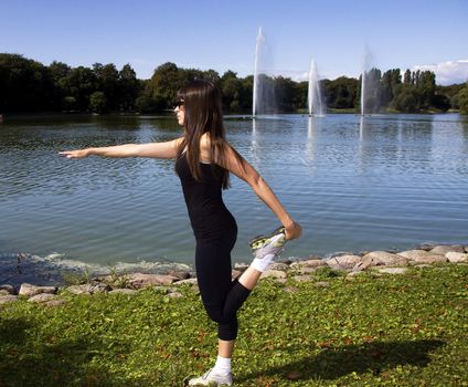 Latina is working out in the park stretching before a run