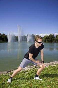 Man working out in a beautiful park by a lake