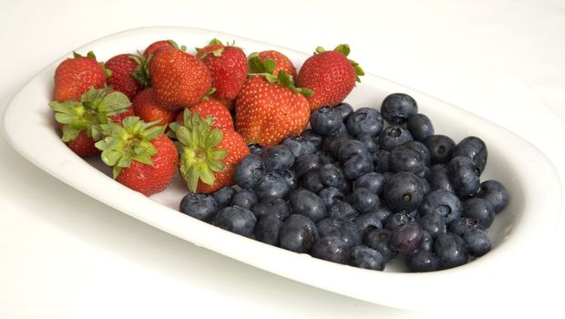 Summer refreshment: Strawberries and blueberries on a white tray.