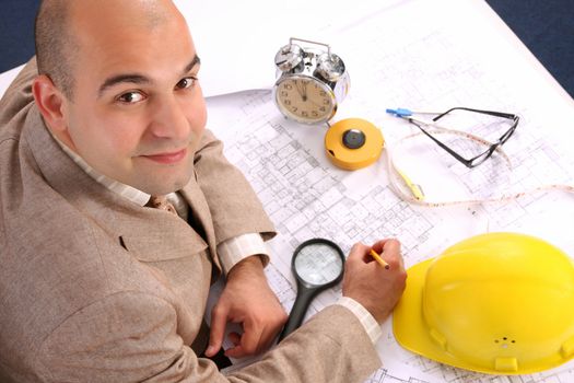 A businessman happiness with architectural plans at desk