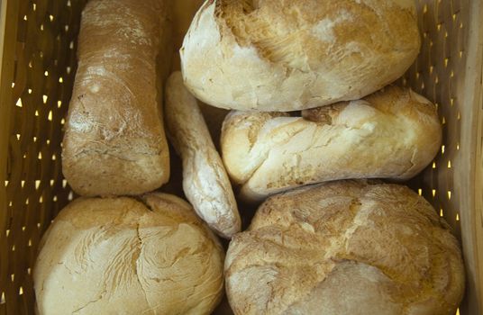 Six loafs of bread inside a basket.