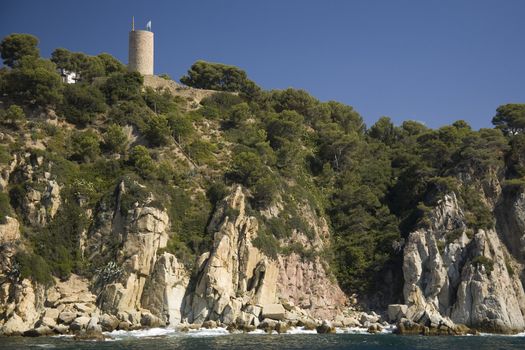 Cove on the Spanish Mediterranean cost, with castle's tower on top.