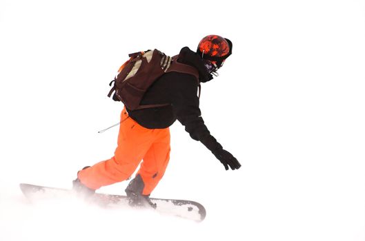 Snowboarder riding down a snow covered hill