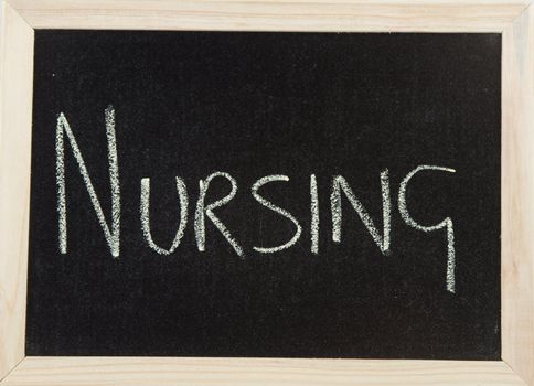 A black board with a wooden frame and the word 'NURSING' written in chalk.