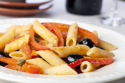 Penne pasta dinner with red bell peppers and black olives