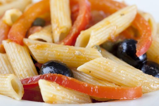 Penne pasta dinner with red bell peppers and black olives