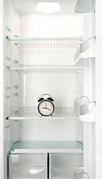 Round alarm clock in an empty refrigerator
