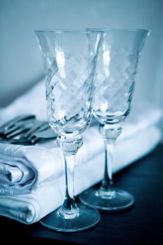 White napkin and two empty glasses for a sparkling wine on a black surface
