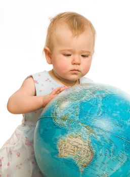 The little girl attentively examines the big globe on a white background
