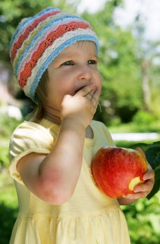 The girl holds an apple