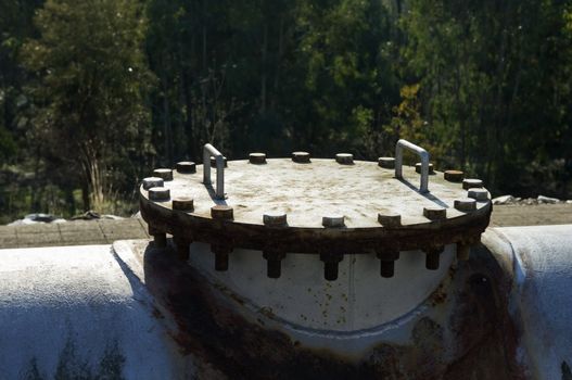 A rusty pipework cover painted in gray