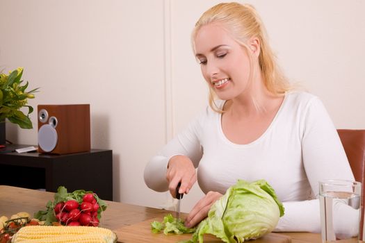 Pretty housewife cutting the vegetables in the kitchen