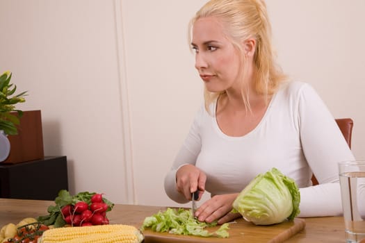 Pretty blond housewife looking very tired of working in the kitchen