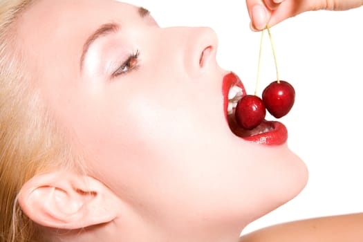 Beautiful blond woman biting in fresh cherries