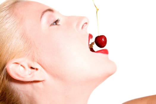 Beautiful blond woman biting in a red cherry