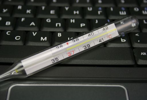 mercurial thermometer over laptop keyboard