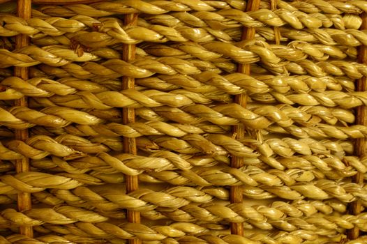 Stock macro photo of the texture of a basket woven from grass cord. The basket is wet and shiny. Useful for layer masks or as a patterned background. Focus falls off at RH edge to give depth to the image.
