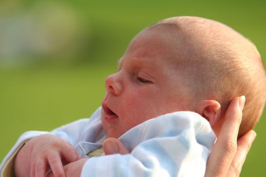 One month baby with the hand of his mother on his head