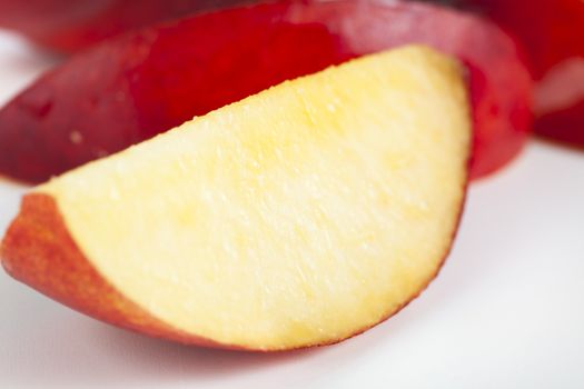 Slice of fresh nectarine, closeup with shallow depth of field.