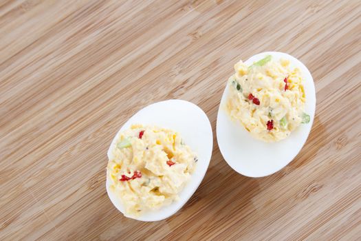 Two fresh gourmet deviled eggs on a table.