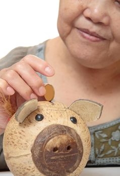 woman putting coins in small piggy bank. Selective focus, Copy space 